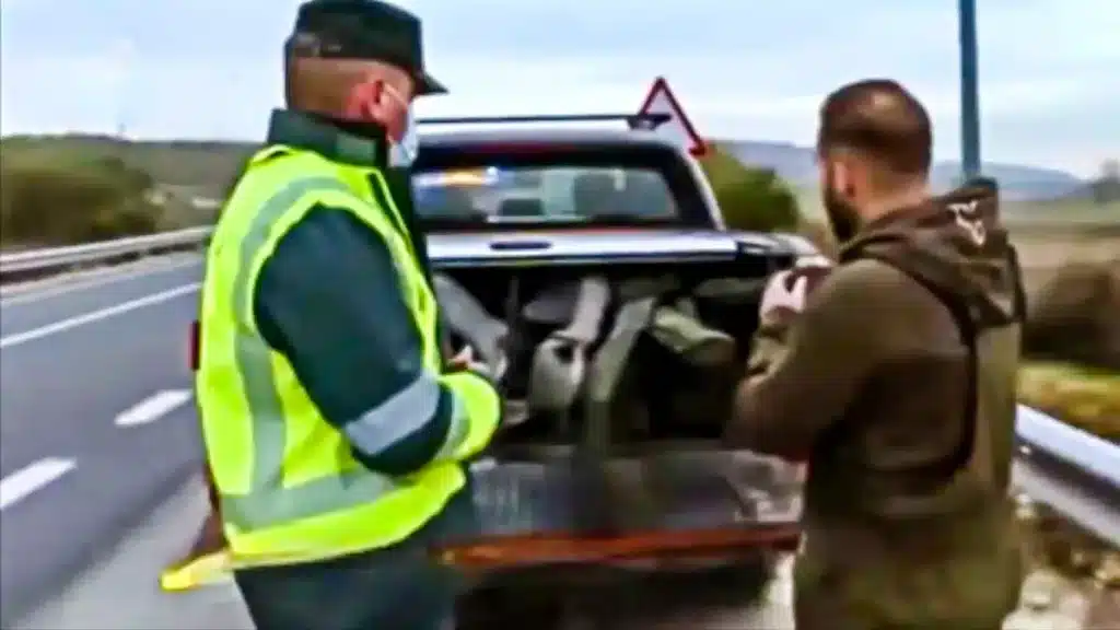 Uno de los agentes con el copiloto del vehículo.