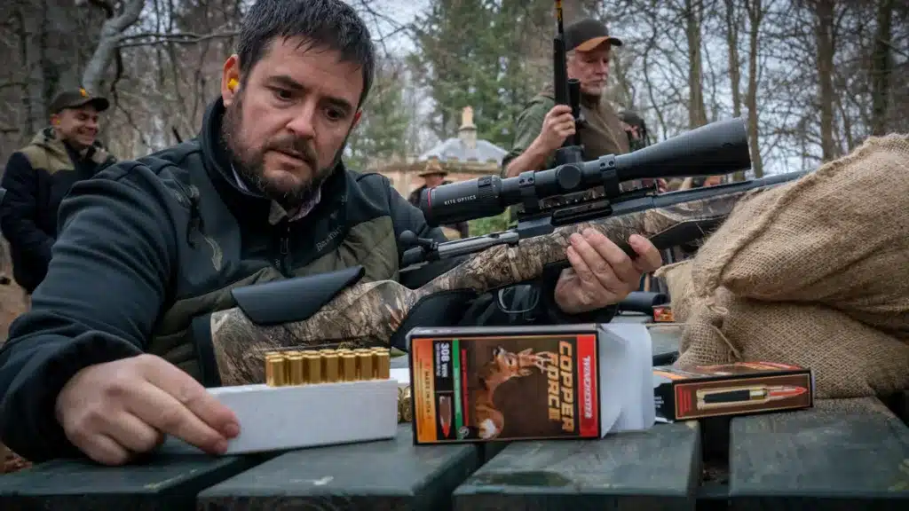 Un cazador carga un rifle en un campo de tiro.